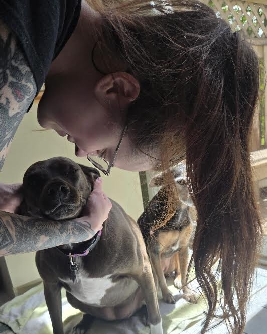 Allison giving a dog a kiss on the head